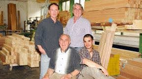 Die drei Inhaber und ein Mitarbeiter in der Werkstatt